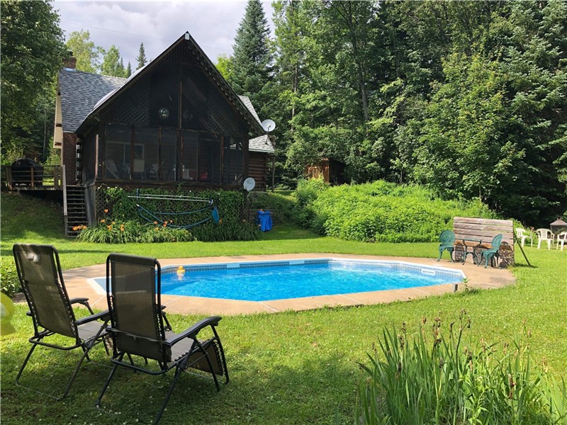 Log cabin with an in-ground pool